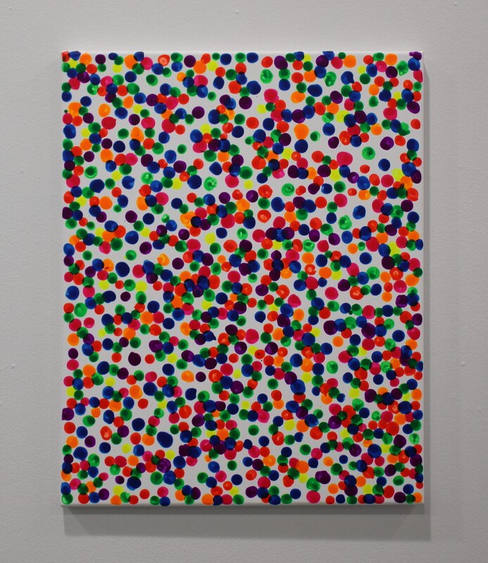An artwork with multicolored dots on a white canvas.
