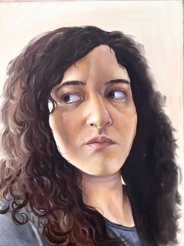 Artist: Skally Benitez. 16 by 20-inch oil on canvas titled Enojona. The portrait is a figure facing the artist looking off to their far right. The portrait is from the shoulders up. The figure has long curly brown hair and facial features are seen in light and shadow.