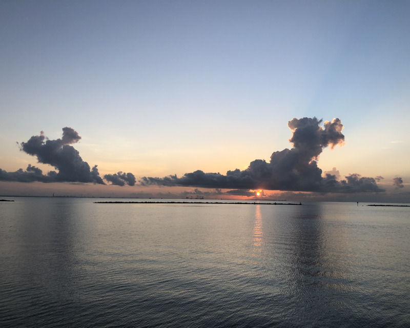 color photograph of a clouded skyline over the water