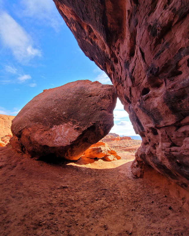 color photograph of red rocks and cliffs with a blue sky