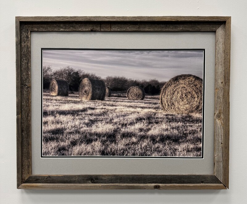 Artist: Scott Pool. 25 by 31-inch framed photograph of hay bales in a field.
