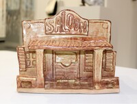 Ceramic sculpture of a Western-style saloon with "SALOON" on the facade.
