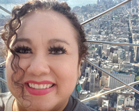 color photograph of a self portrait taken against a city view taken from a great height