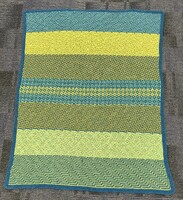 Artist: Lisa Louis. 60 by 40-inch mosaic crochet afghan. Afghan crocheted in intricate geometric patterns in hues of green and blue.