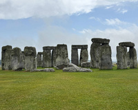 Stonehenge with large standing stones on a grassy field under a cloudy sky.