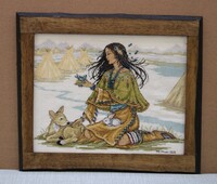Cross-stitch art of a woman with animals in a natural setting, framed in wood.
