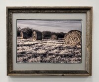 Artist: Scott Pool. 25 by 31-inch framed photograph of hay bales in a field.