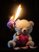 Teddy bear holding a flaming rose and a pink heart with text. Transcribed text: love ya.