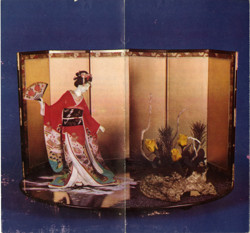 Traditional Japanese screen (byōbu) with a figurine in a red kimono and a floral arrangement.