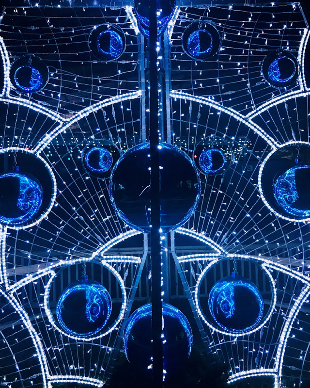 Illuminated blue and white circular decorations with a complex, symmetrical design.