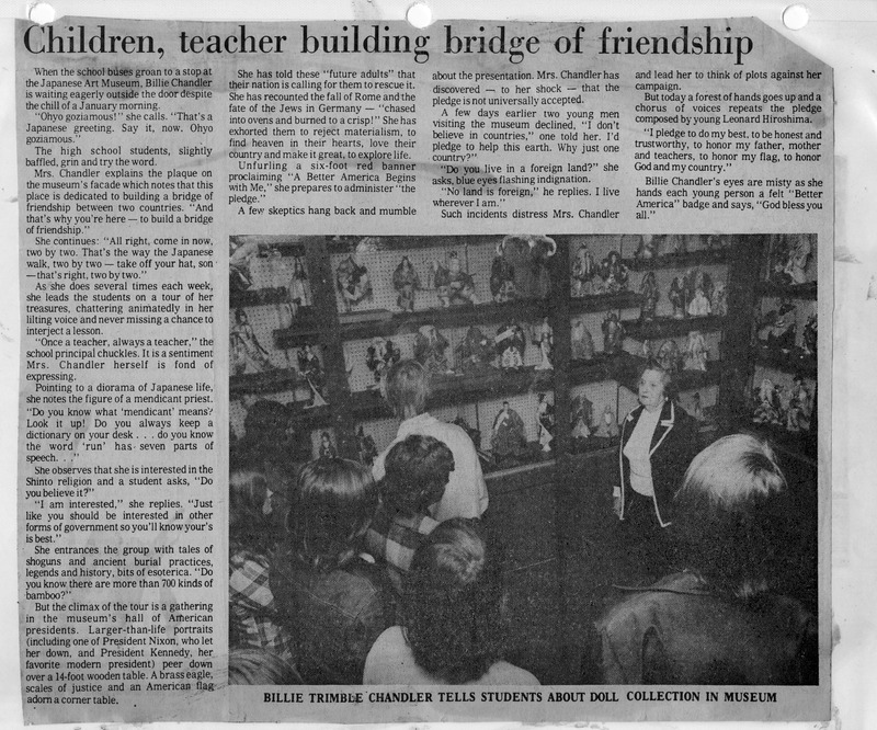 Black-and-white newspaper clipping with article about Billie Chandler at the Japanese Art Museum and a photograph of her with students viewing a doll collection.
Transcription:
Title: Children, teacher building bridge of friendship
Caption: BILLIE TRIMBLE CHANDLER TELLS STUDENTS ABOUT DOLL COLLECTION IN MUSEUM