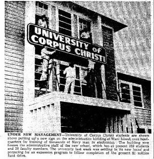 Students putting up the new university sign in the administration building