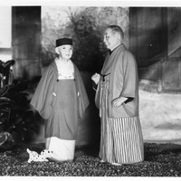 Black-and-white photo of two dolls in traditional Japanese attire with a small toy dog.