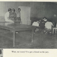 Students chatting by a ping pong table a photograph in TheSilverKing1959. The caption reads "What, me worry? I've got a friend on the jury."