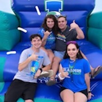 Four students on a blow up jump house at the Beach Bash TAMUCC 2022. 