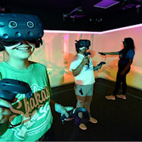 Three students in the immersive reality lab on campus 2022-2023. They are using the VR headsets