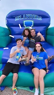 Four students on a blow up jump house at the Beach Bash TAMUCC 2022. 